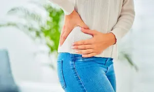 Témoignage : une femme se tient la hanche, souffrant de douleurs. Une infiltration de la hanche pourrait soulager.
