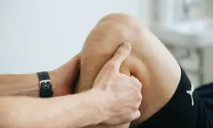 Un kinésithérapeute examine le creux poplité d'un patient, peut-être pour diagnostiquer une douleur ou une blessure.